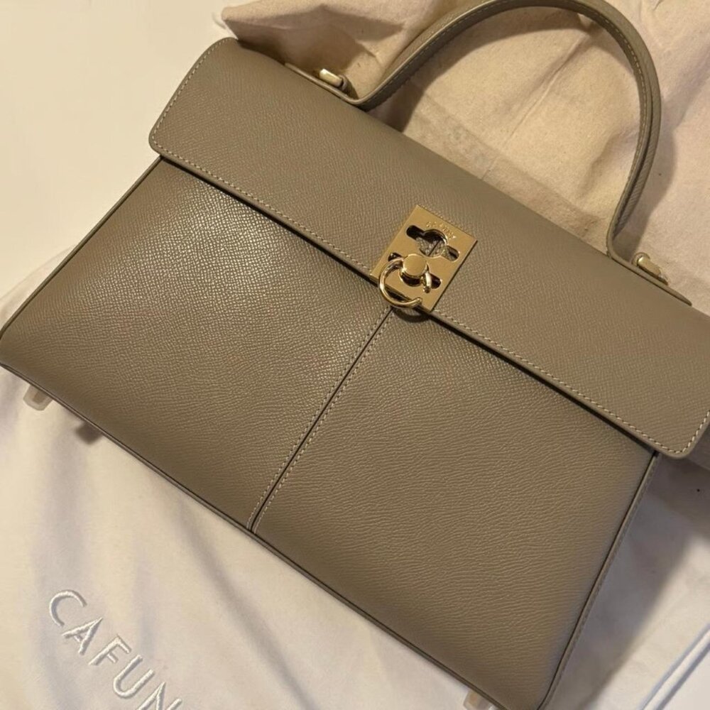 CAFUNE fine leather with clear grain pattern, paired with metal snap fasteners